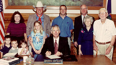 Ron Wilson, Cowboy Poet Lariat, and his family pose with Kansas Governor Bill Graves. 